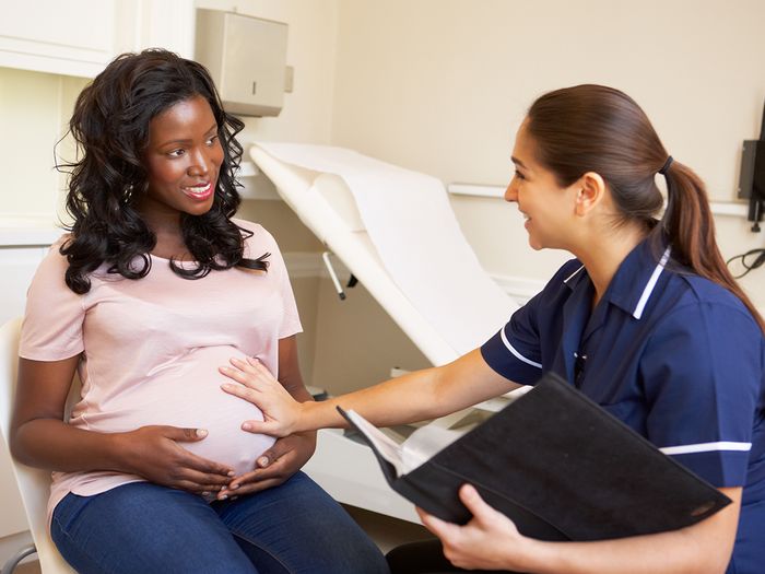 Pregnant woman smiling in a doctors office