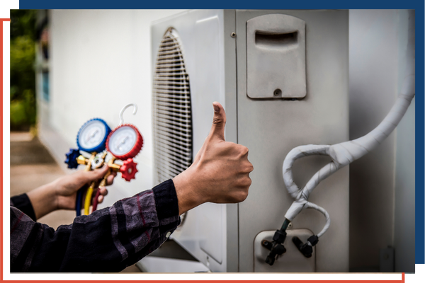 HVAC tech kneeling next to a unit giving a thumbs up