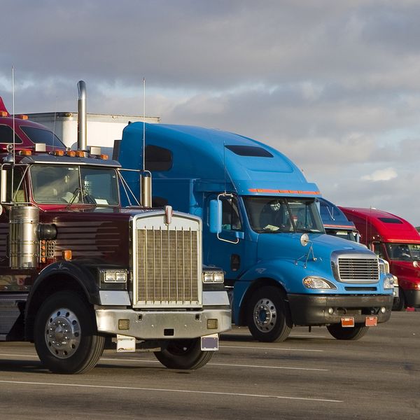 Multiple semi-trucks parked at a truck stop.