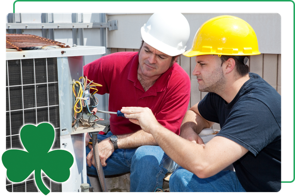 two workers operating on ac condenser outdoors