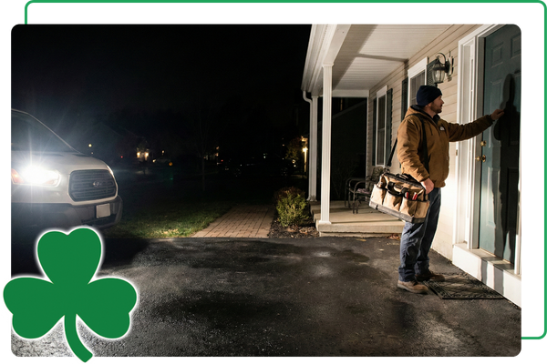 Technician arriving at a home at night carrying tool bag