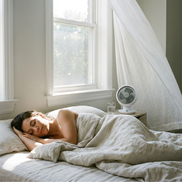A person sleeping comfortably in a cool bedroom on a sunny day, representing energy-efficient climate control.
