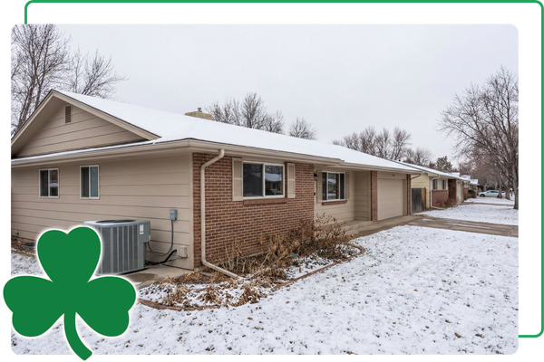 Snowy home with an HVAC unit