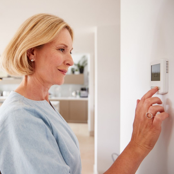 Woman changing her thermostat
