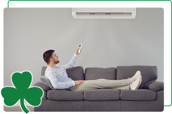 man on couch, adjusting mini split AC with remote