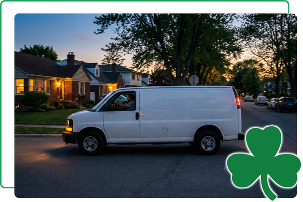 Service van driving down a suburban street at dusk
