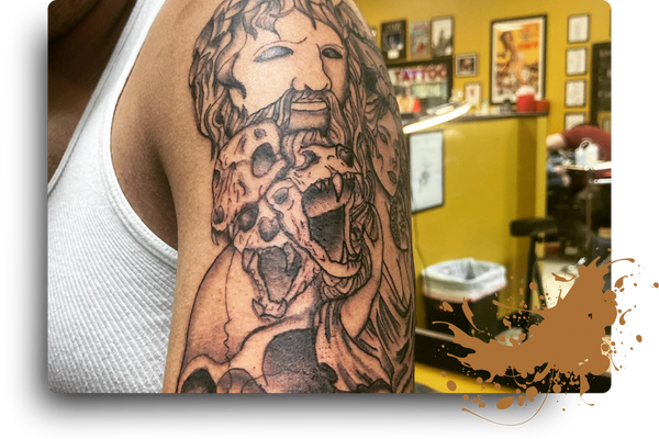 upper arm tattoo, view of tattoo shop reflected in mirror in background