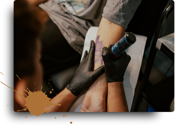 tattooing client's arm