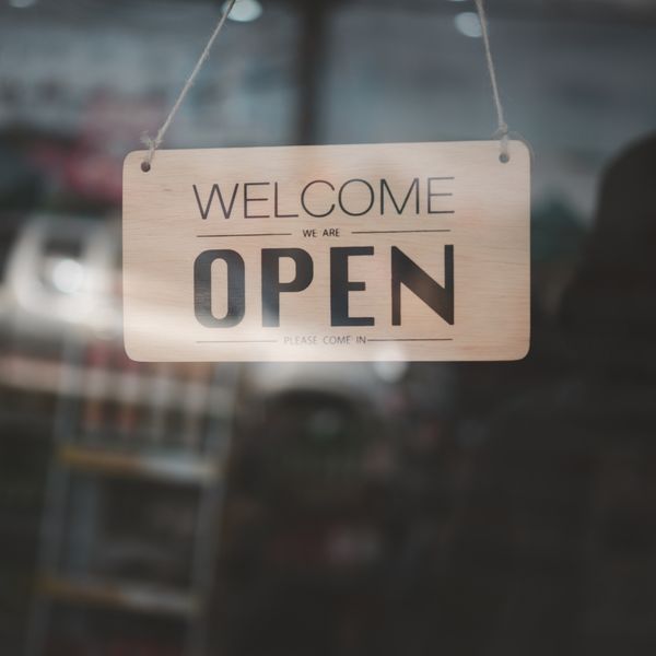 'Open' sign hangin from a business entry