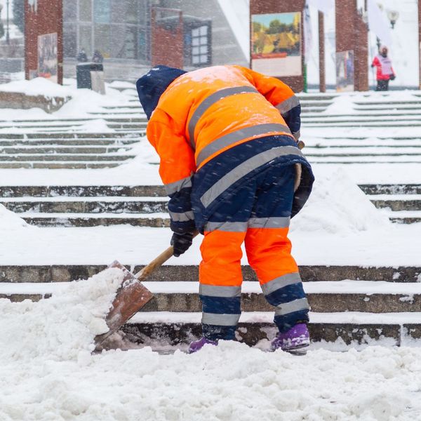 man shoveling steps of business