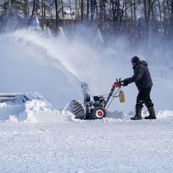 man using snow blower