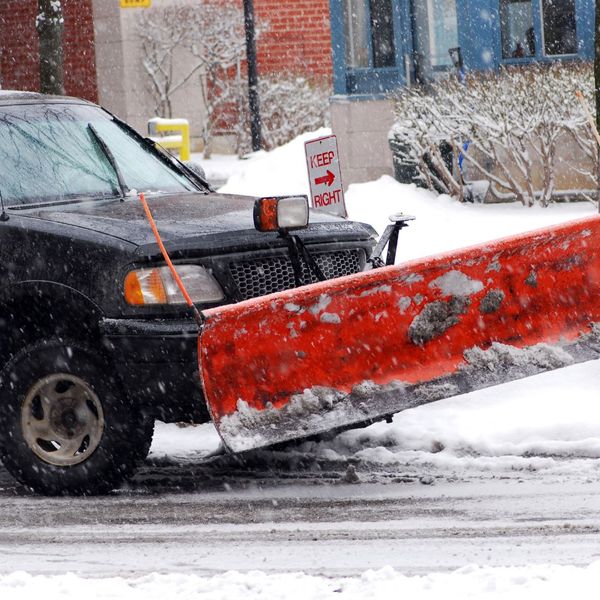 A truck with a snow plow attached to the front