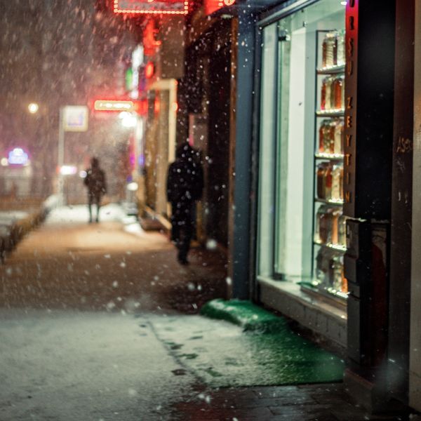 Snow falling in front of a storefront