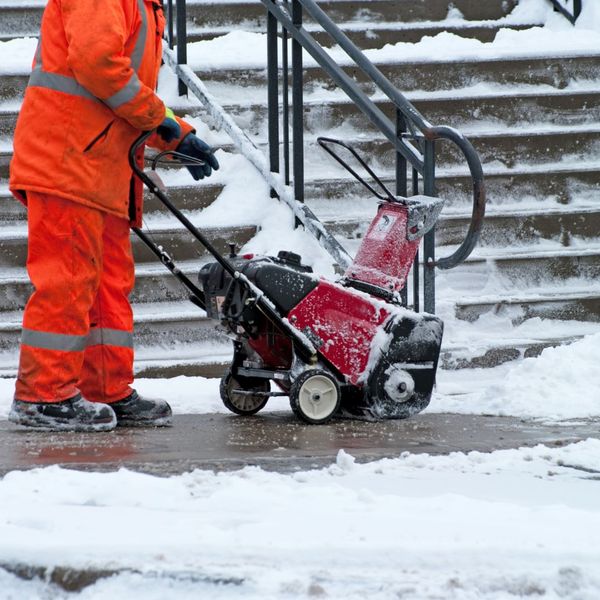 Image of a worker using a sidewalk snow plow