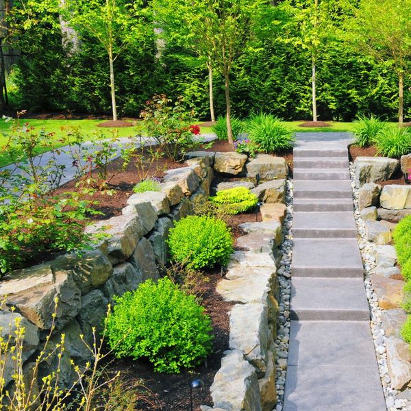 backyard pathway with stone retaining walls and plants