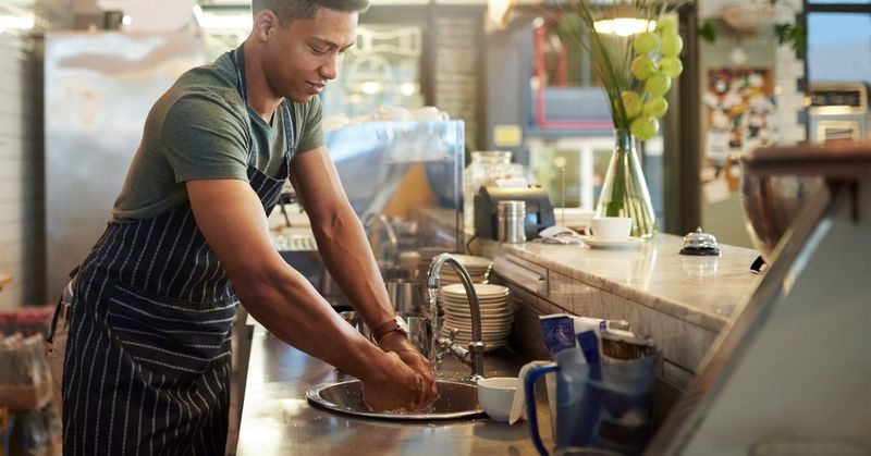 Cafe owner washing his hands in the sink