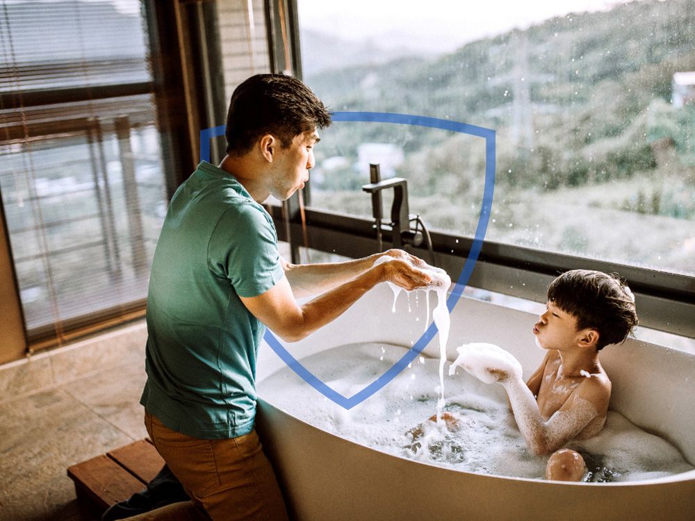 Father and son playing with bubbles in the bath