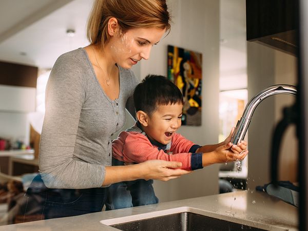 Mother and son washing hands in the sink