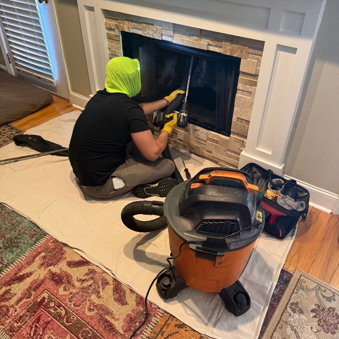 technician sitting in front of fireplace with shopvac