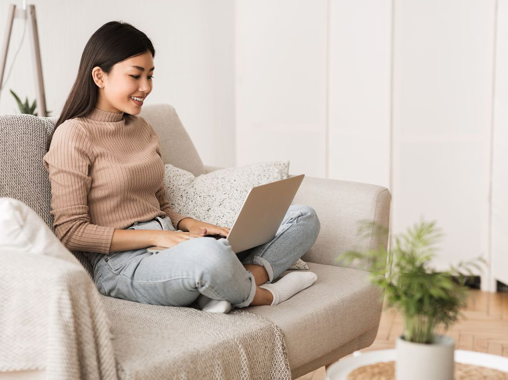 Woman smiling at her computer at home