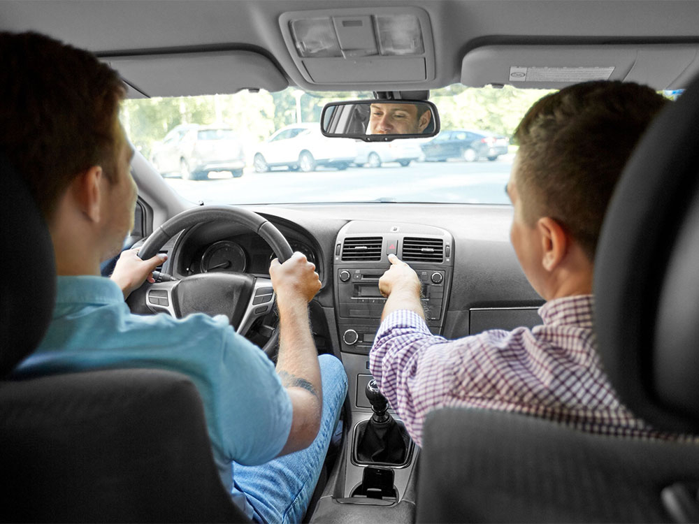 Driving instructor with teenager in car