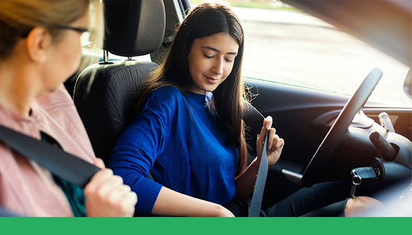 teenage driver putting on seat belt