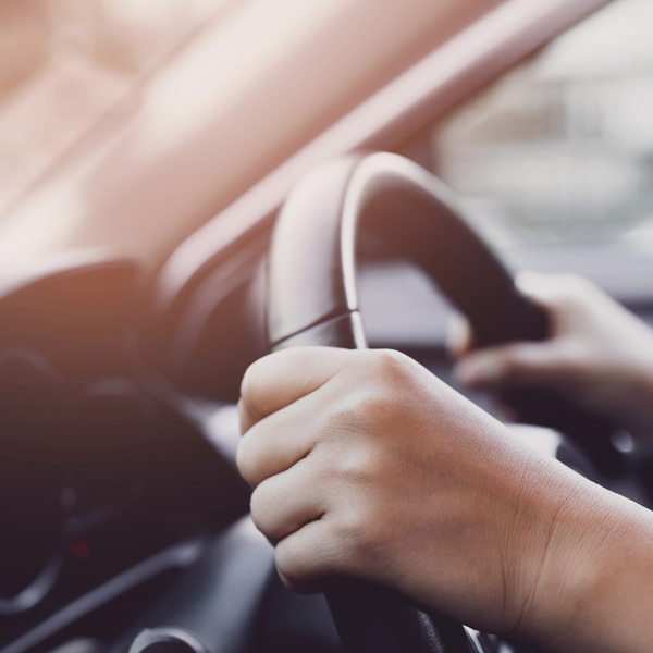 person gripping a steering wheel.