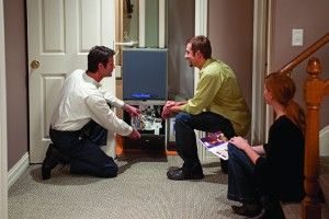 Image of two men working on a heater