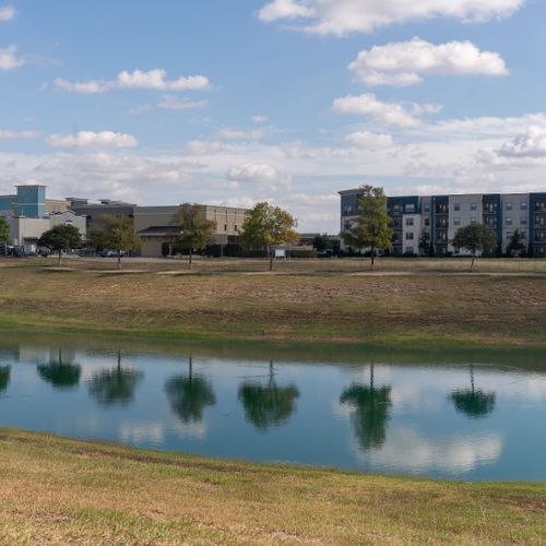 view across pond, apartments in distance