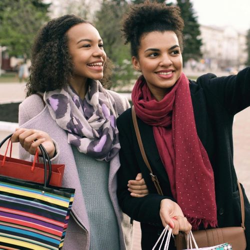 girls laughing while shopping posing for a picture