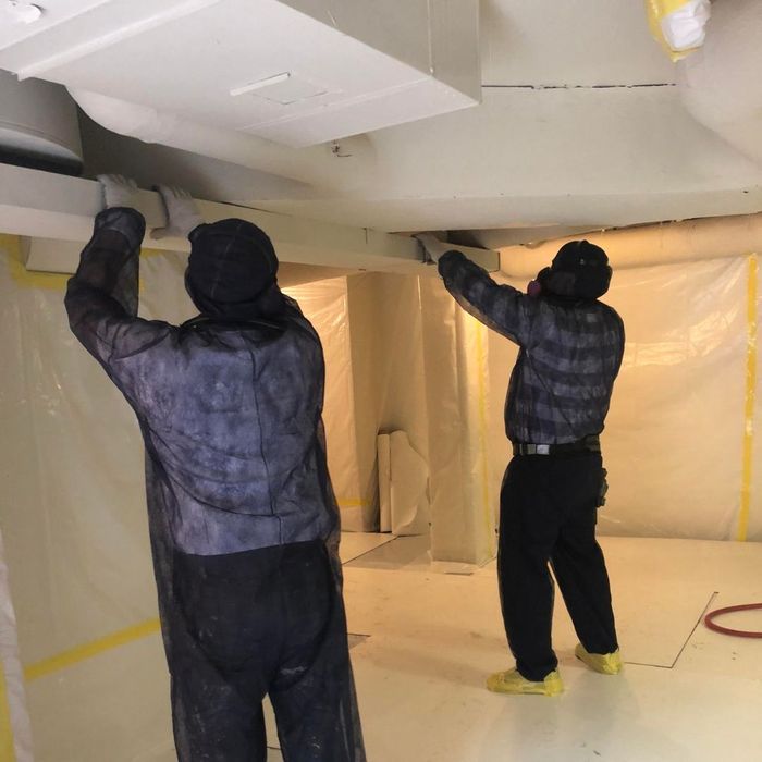 2 men inspecting an area during an asbestos removal 2 men inspecting an area during an asbestos removal