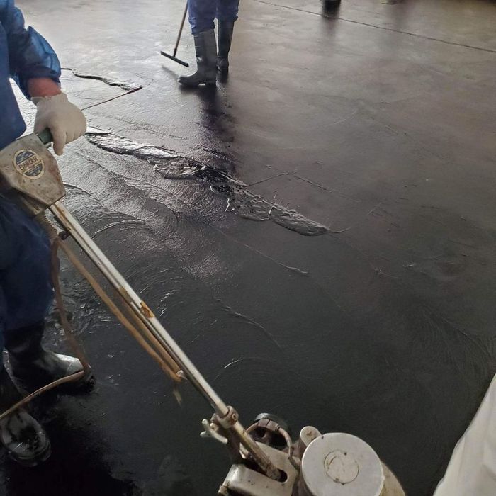 workers re-sealing a floor that was previously exposed to asbestos workers re-sealing a floor that was previously exposed to asbestos