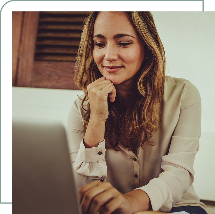 woman smiling while using a laptop