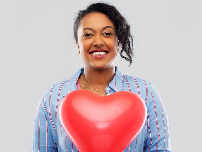 smiling woman holding a heart balloon