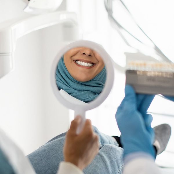 A patient's teeth in a small mirror's reflection