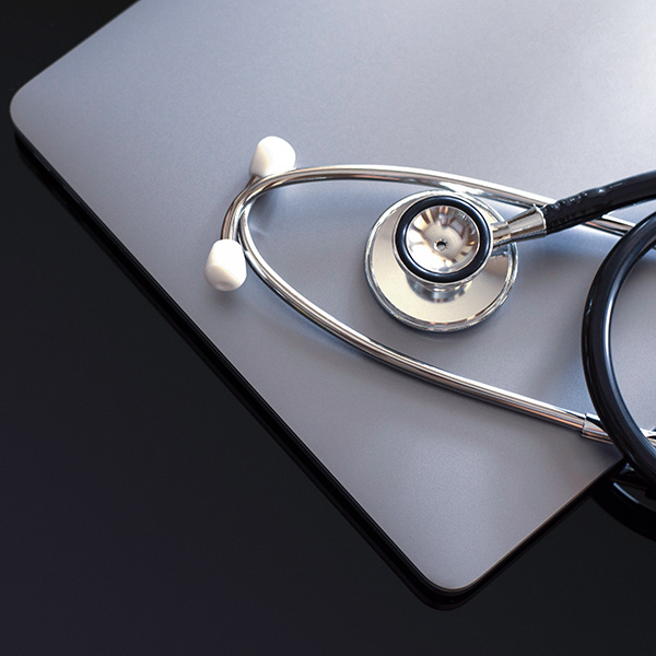 a stethoscope laying on top of a laptop