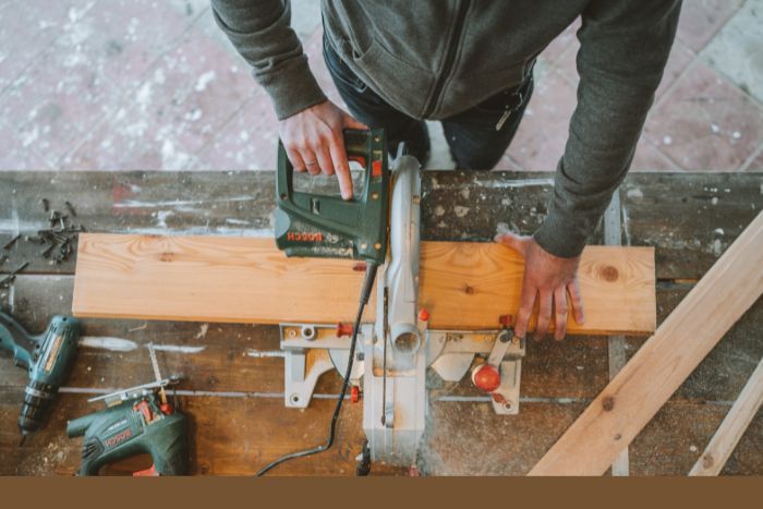 man cutting wood with machine