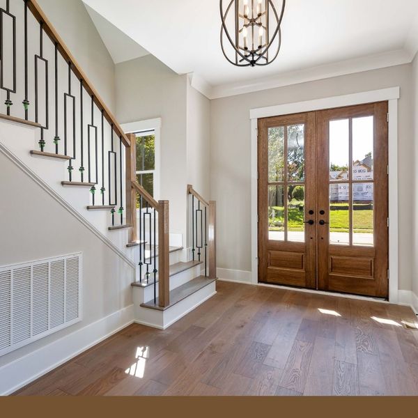 entryway, lovely wood and iron stair rail and wooden double doors