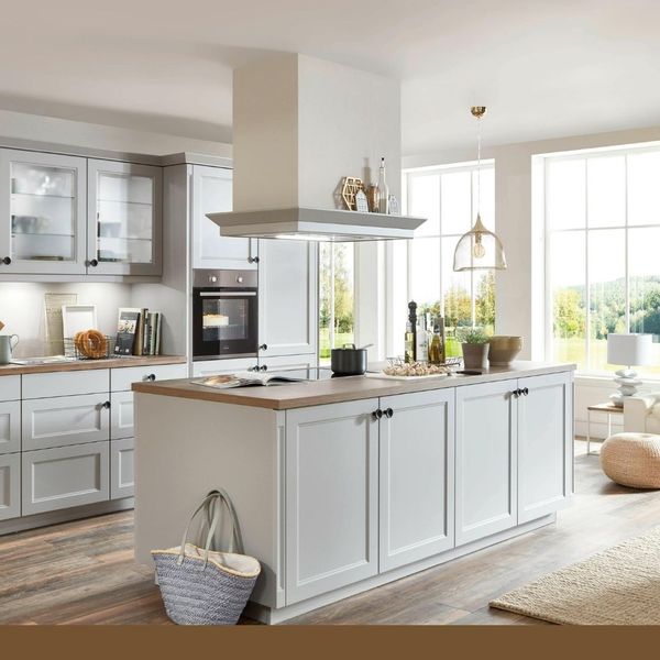 light gray kitchen with large island under oven vent