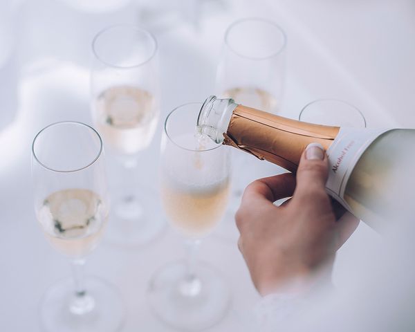 A woman pouring champagne into glasses