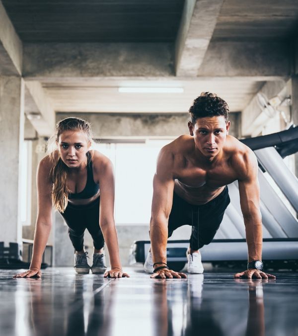 A young man and woman doing planks