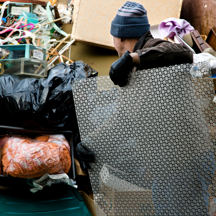 man loading junk into a dumpster