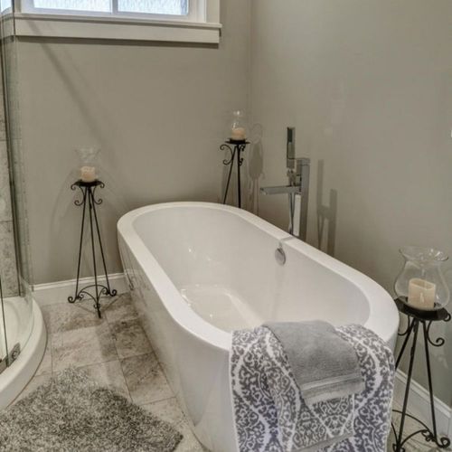 White freestanding bathtub in a tiled bathroom