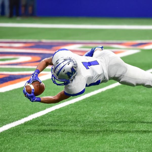 a football player diving into the end-zone