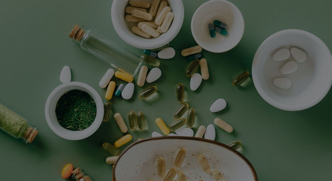 supplements in cups on green background