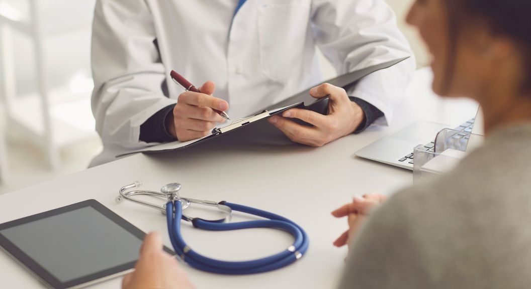 doctor writing on clipboard