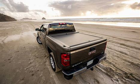 Truck on the beach with water behind it Truck on the beach with water behind it