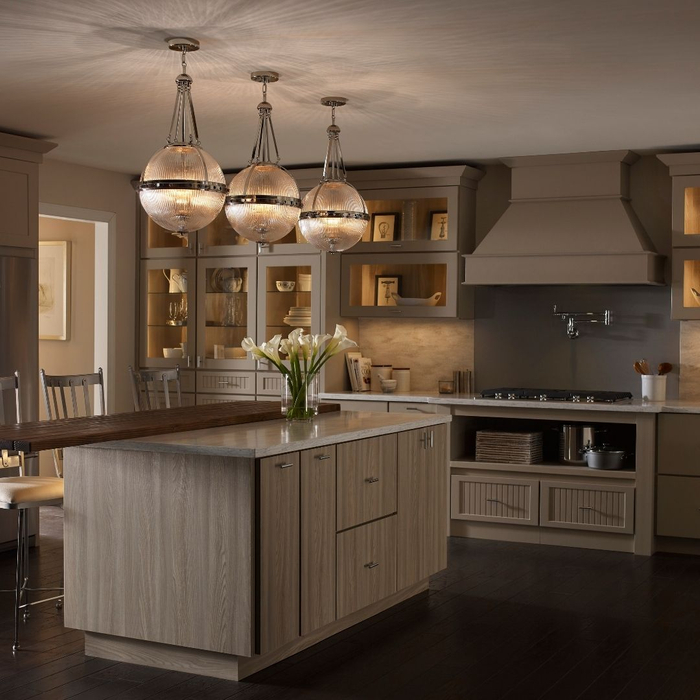 Warmly lit kitchen featuring three large glass pendant lights.