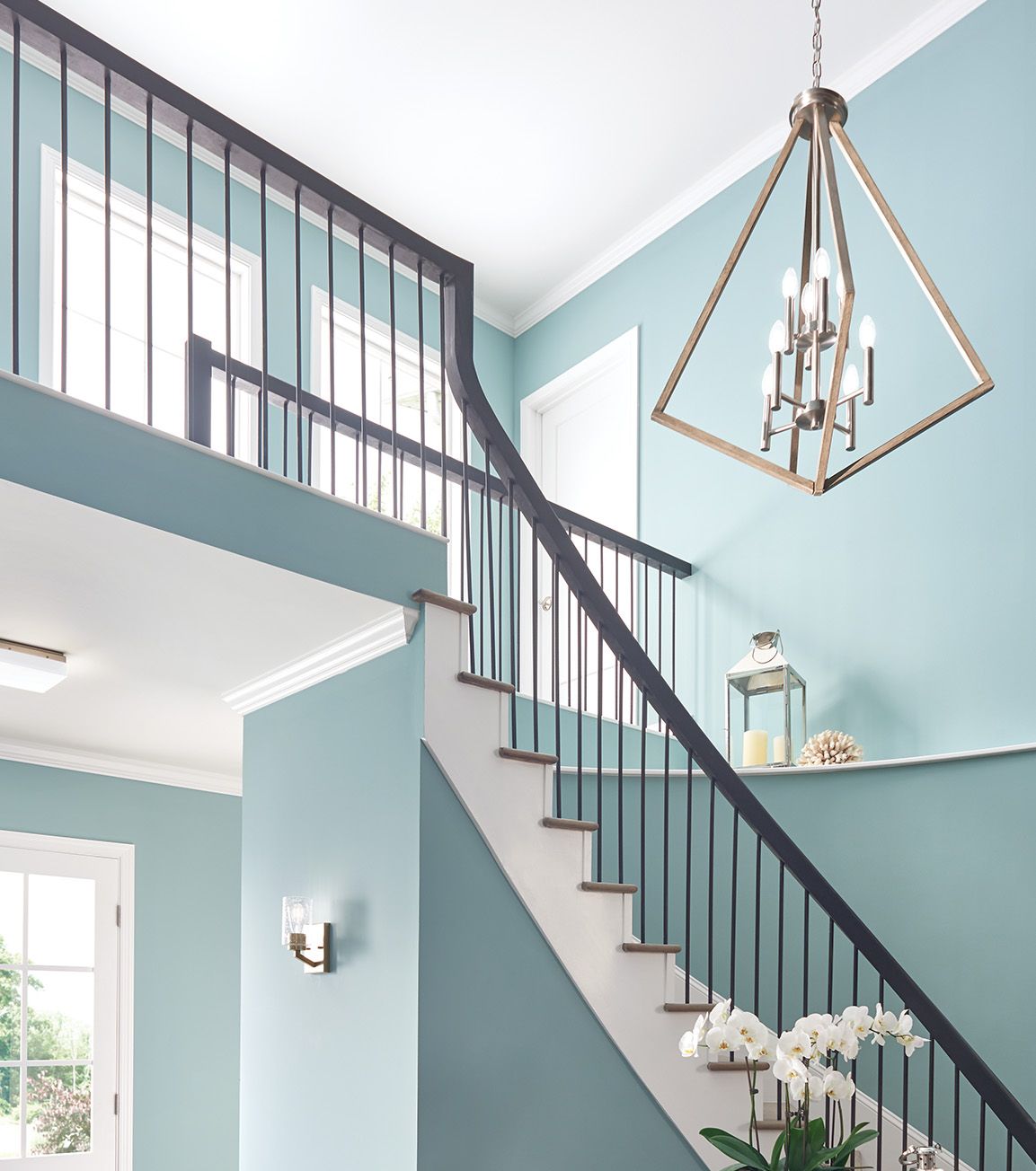 angular chandelier above bright blue stairway