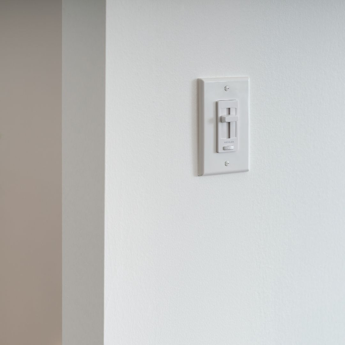 White wall-mounted dimmer switch with a vertical slider.